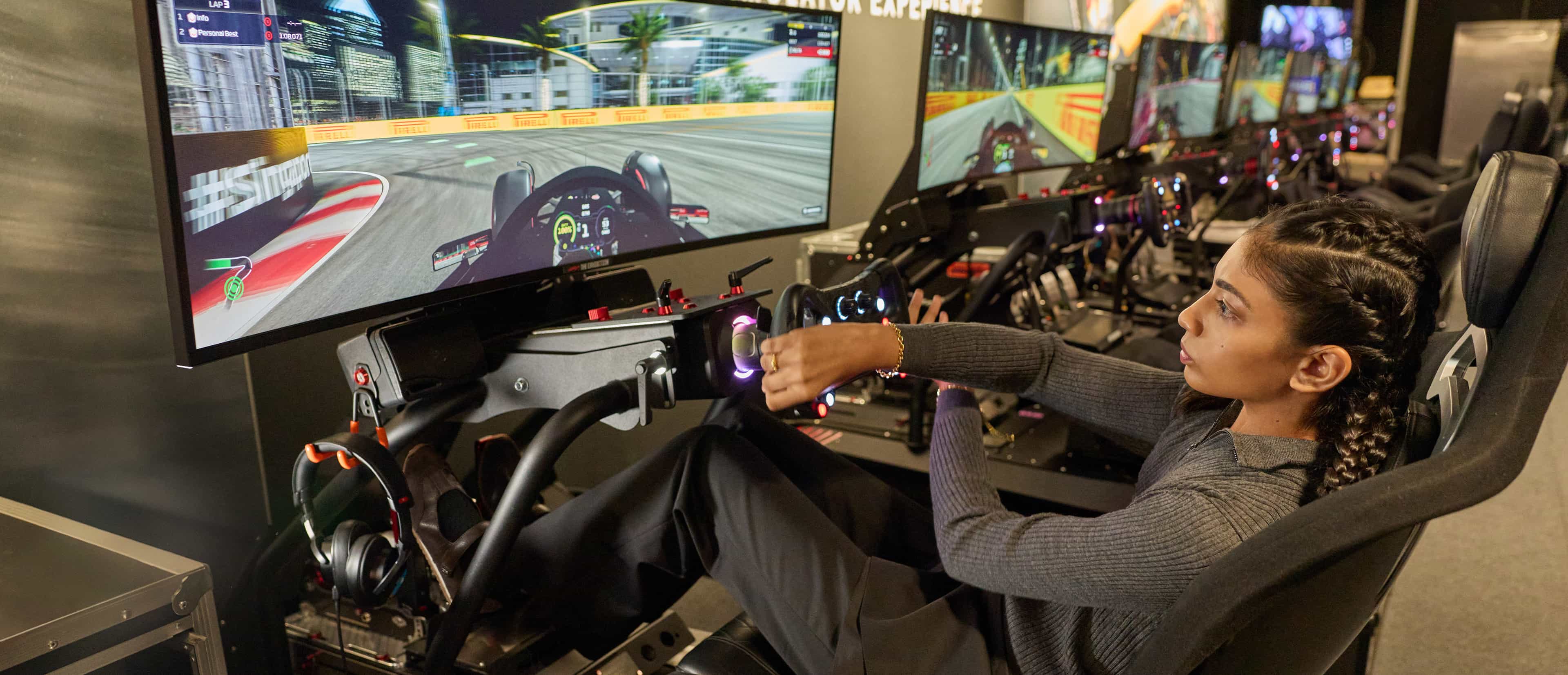 Kareen Kaur enjoying a racing simulator at The F1® Exhibition Singapore - CHARLES & KEITH