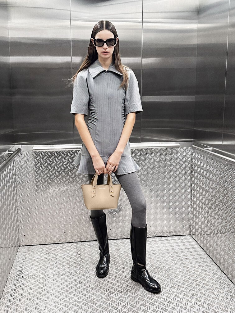 Botas de cano alto e biqueira redonda combinam idealmente com uma saia mini e meias-calças para um look preppy elegante.