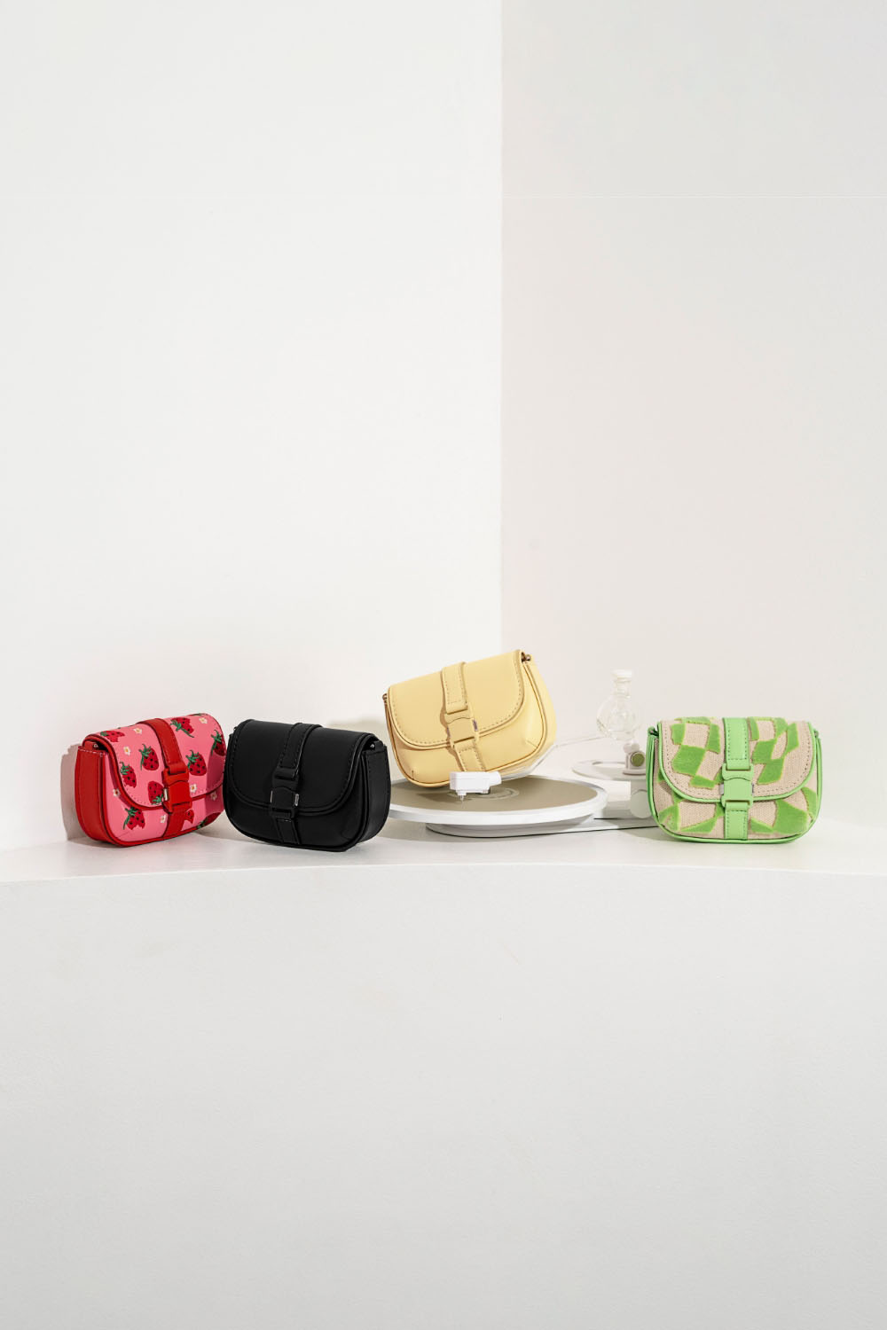 Women’s pink Zetta belt buckle strawberry-print mini bag, Zetta black and butter belt buckle mini bag, and Zetta belt buckle checkered mini bag -CHARLES & KEITH