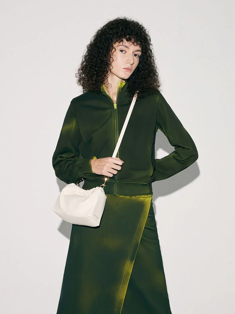 A crossbody bag with the strap worn diagonally across the torso and the bag resting right at the hip.