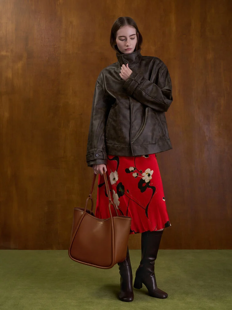 A bright red floral midi dress paired with dark-brown knee-high boots.