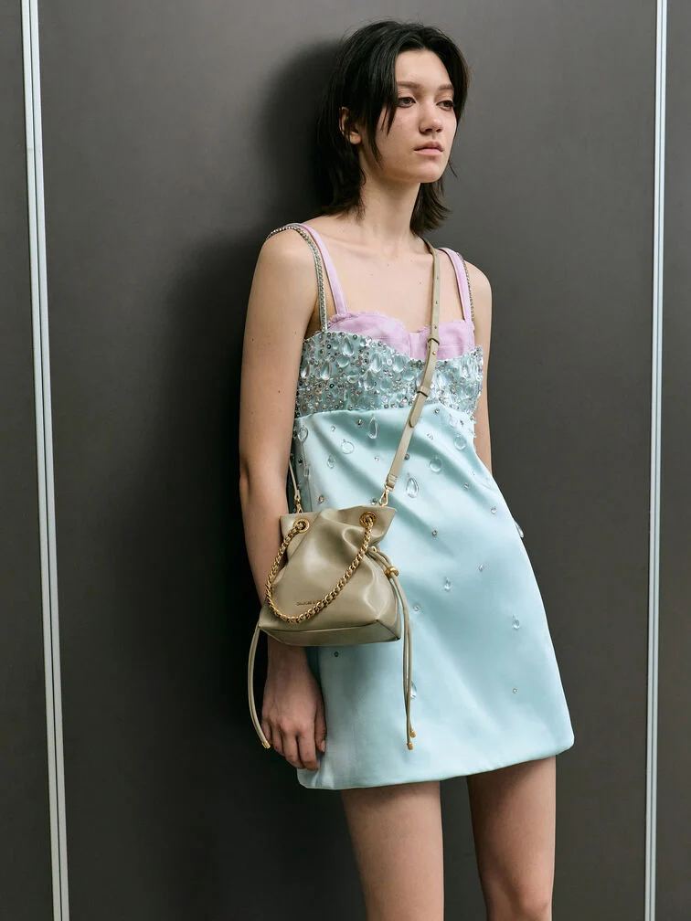 Slouchy Crossbody Bag in blassem Oliv mit Kordelzug-Detail.