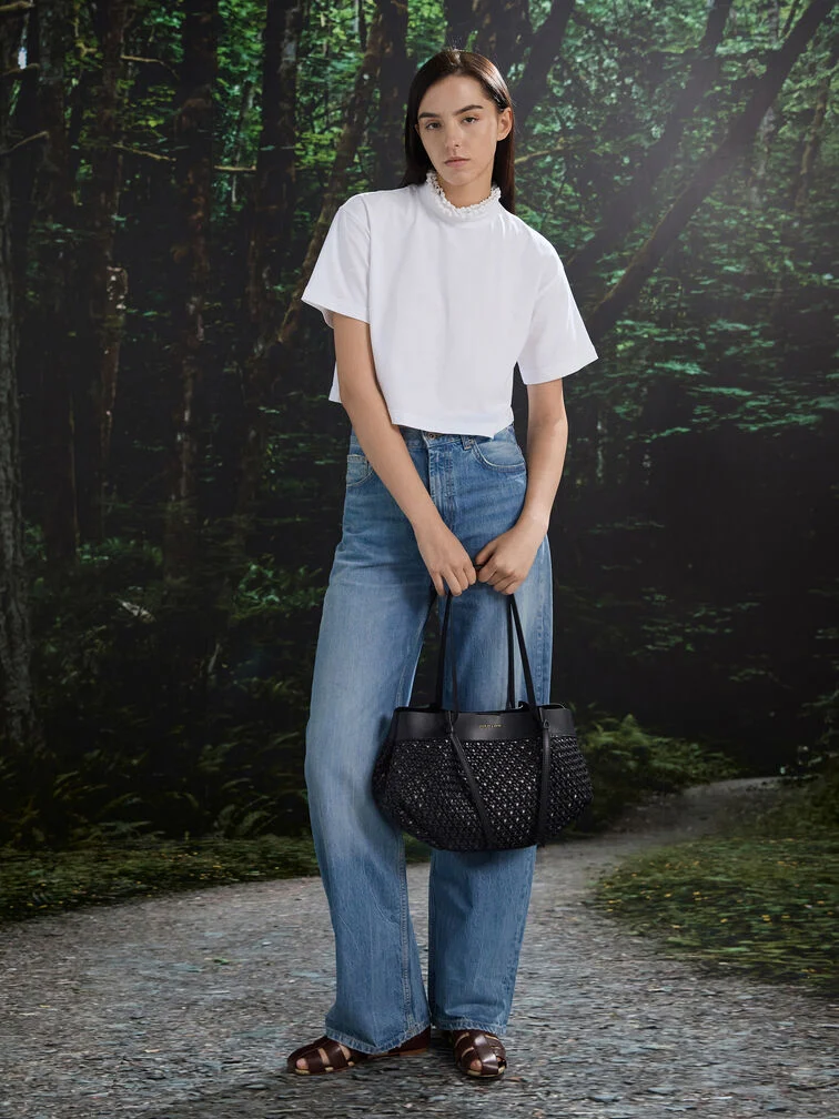 En løs t-shirt parret med jeans og sandaler for et outfit, der føles ubesværet, men velgennemtænkt.
