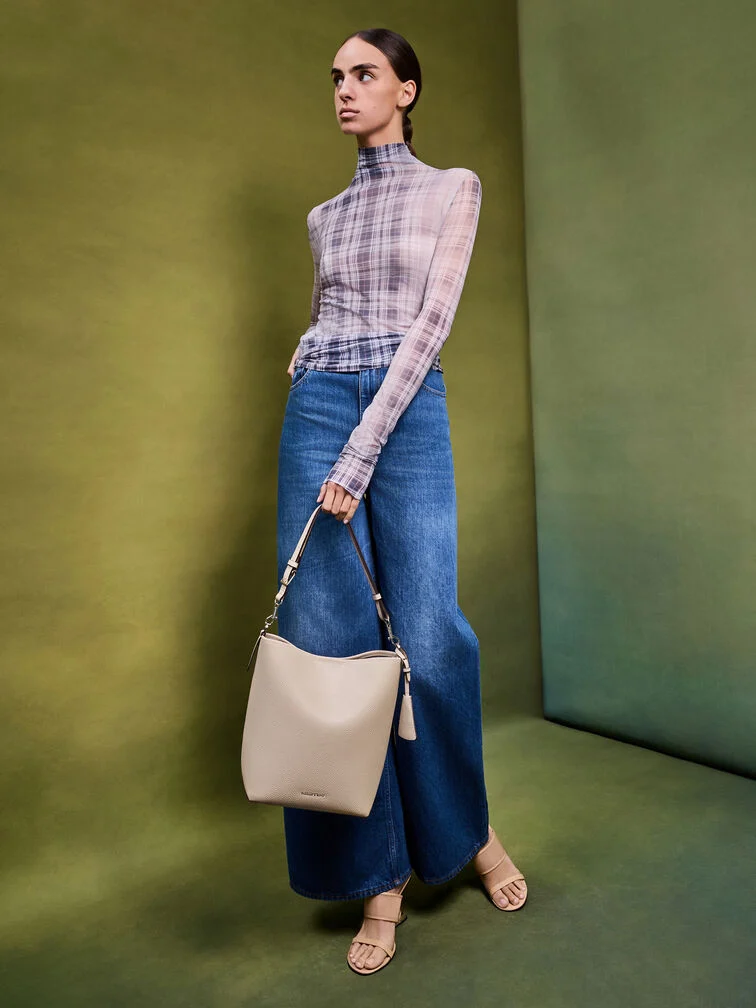 Wide-leg jeans styled with a sheer top and strappy heeled sandals for an effortless daytime look.