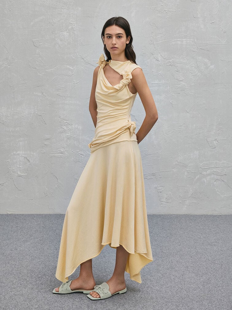  Ein gelbes, fließendes Maxikleid kombiniert mit mintgrünen Pantoletten 