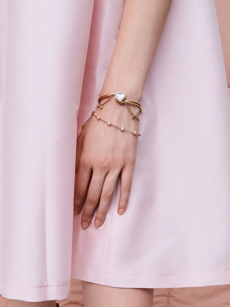 A statement gemstone heart bracelet and dainty pearl bracelet for an elegant bracelet stack.
