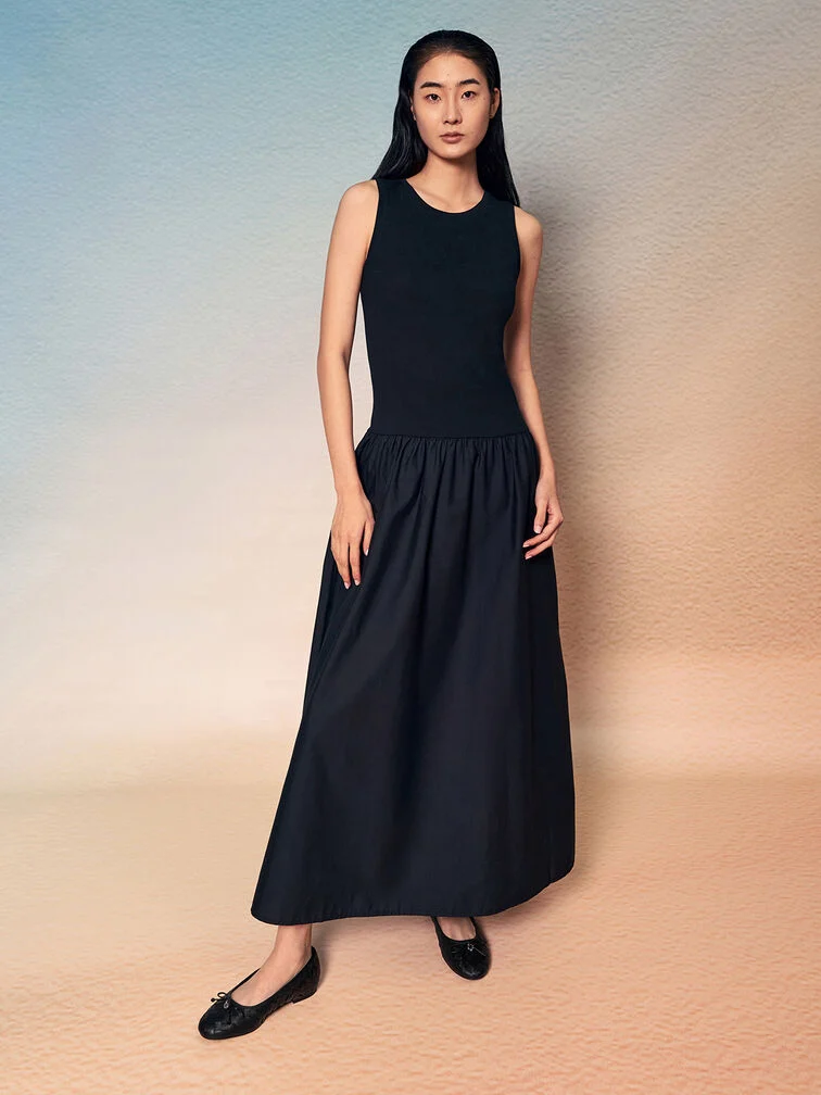 Schwarze Ballerinas kombiniert mit einem schwarzen Maxikleid schaffen eine durchgehende visuelle Linie 