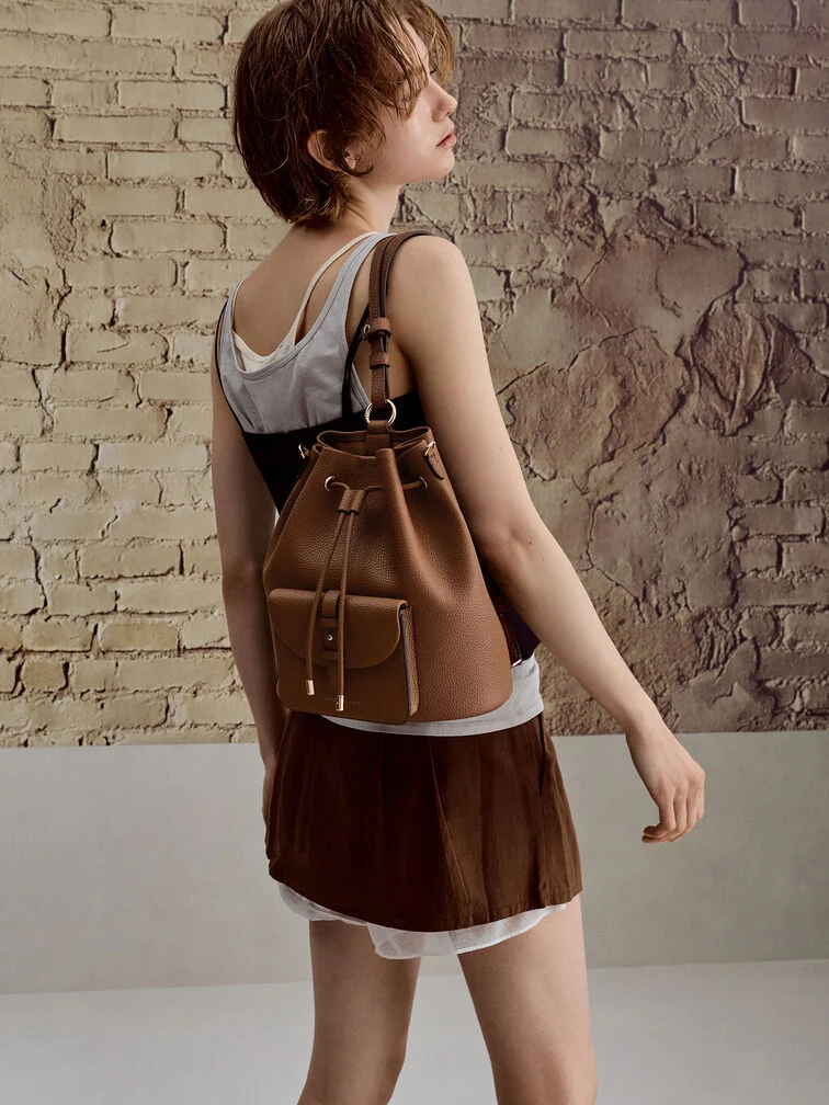 The Beryl backpack with both shoulder straps carried on one shoulder for a casual and cool aesthetic.