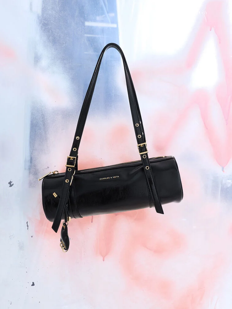 Rey elongated shoulder bag in black, featuring a long, cylindrical shape.