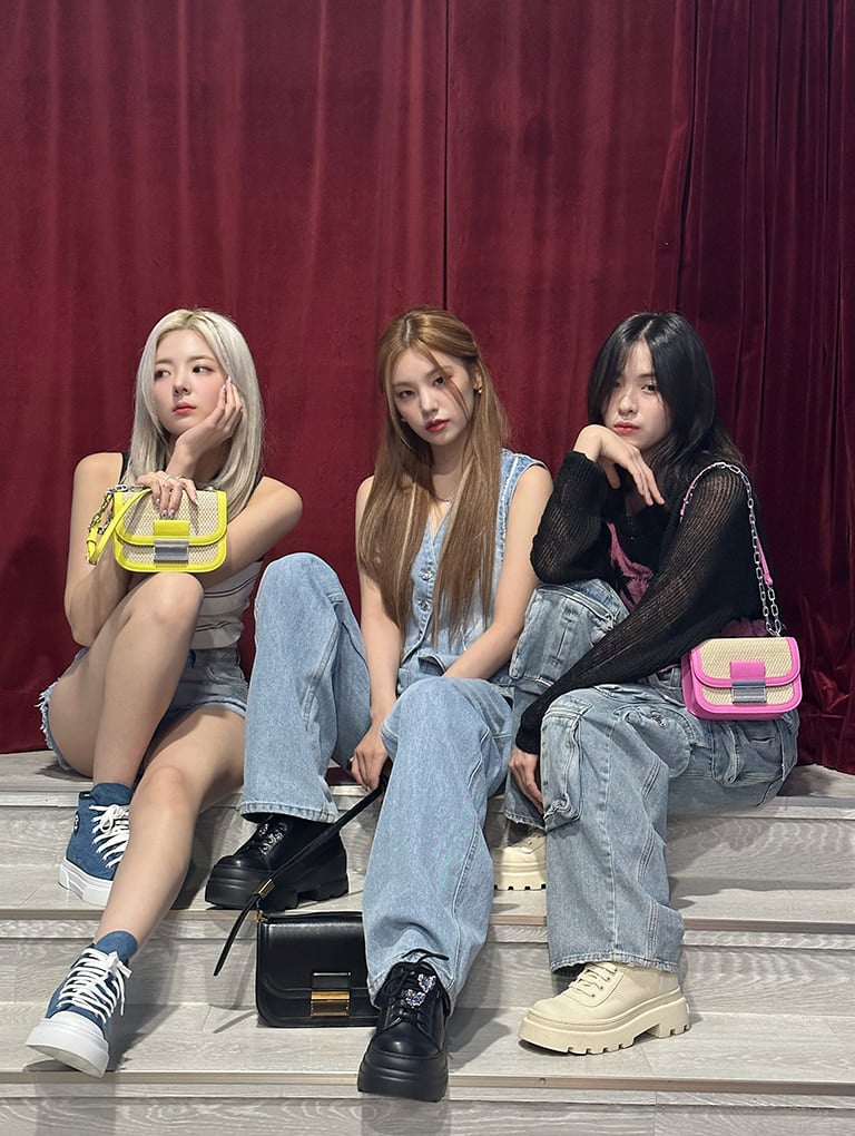 Women’s Charlot raffia chain strap bag in pink and yellow, as seen on Ryujin and Lia, and Charlot bag in black, as seen on Yeji - CHARLES & KEITH