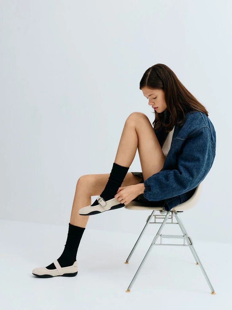 Weiße Mary Jane Sneaker kombiniert mit schwarzen Crew-Socken für einen schicken Layering-Look.