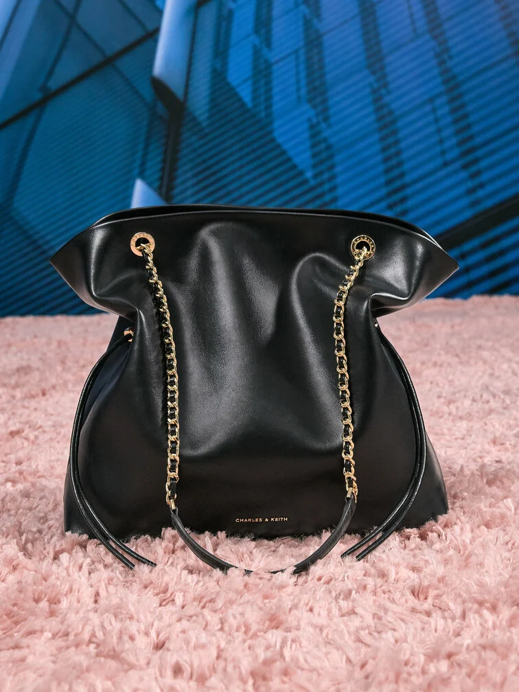 Slouchy Tote Bag mit Kordelzug und geflochtenen Kettenriemen.