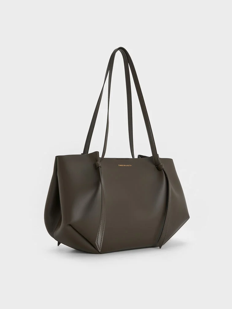 Moosgrüne Tote Bag mit weich strukturierter, geometrischer Form.