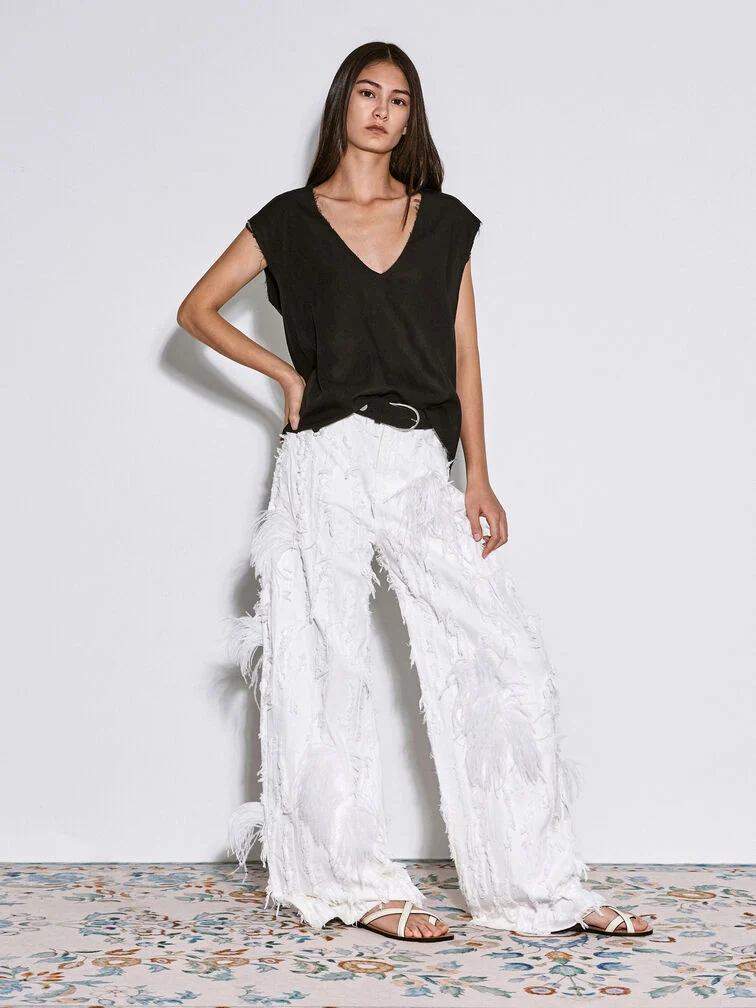 Kombinieren Sie detailreiche Wide-Leg-Hosen mit schlichtem Schuhwerk, um eine bold, aber raffinierte Ästhetik zu schaffen.